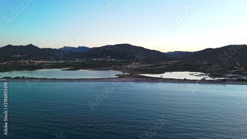 Stunning aerial perspective flying over a beautiful coastline with a turquoise sea and a sandy beach separating the ocean from a lagoon