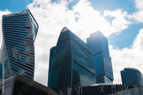 Photography group of modern skyscrapers stands tall under a bright sky filled with clouds