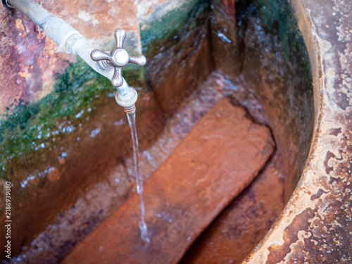 Natural healing mineral spring flowing from a metal tap in Bardejov Spa, Slovakia, representing spa treatment, drinking cure, balneotherapy, mineral water and health tourism.