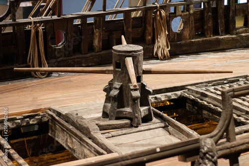 Foto Wooden ship's capstan with long handles positioned on the deck, surrounded by ro