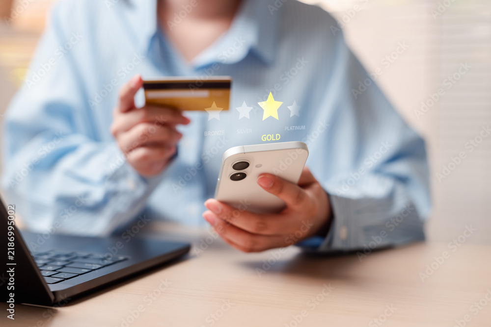 Obraz premium Customer loyalty program membership reward and premium status upgrade. Woman hands holding smartphone and credit payment for online shopping.