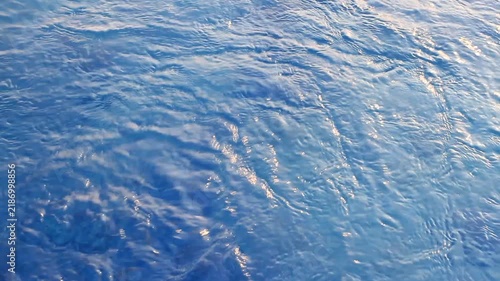 Gentle ripples dance across deep blue water.
