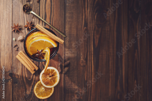 Fotografía Mulled wine with orange and cinnamon on a rustic wooden table ready for autumn