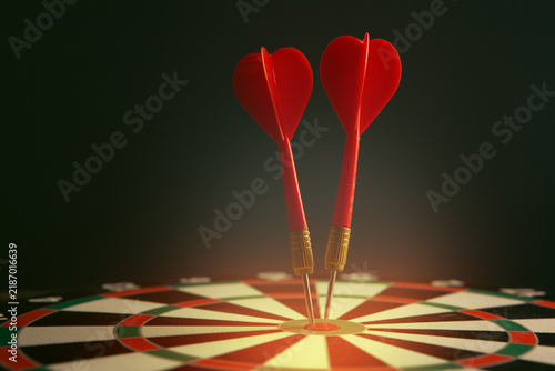 Quadro su tela darts arrows in the target center on a dark background.