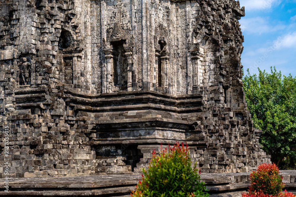 Fototapeta premium Architectural collection of Candi Kalasan stone temple structure and reliefs under blue sky