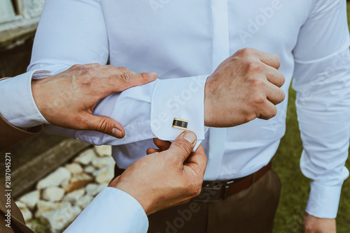 Cuadro en lienzo Man adjusting elegant gold cufflink on white shirt before formal event