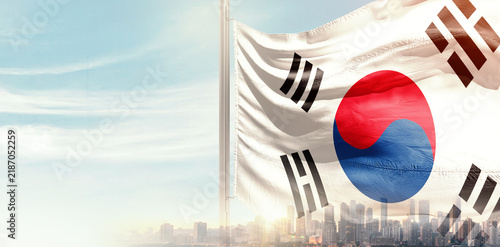 Fotografie South Korea national flag wavering in beautiful clouds with building skyline