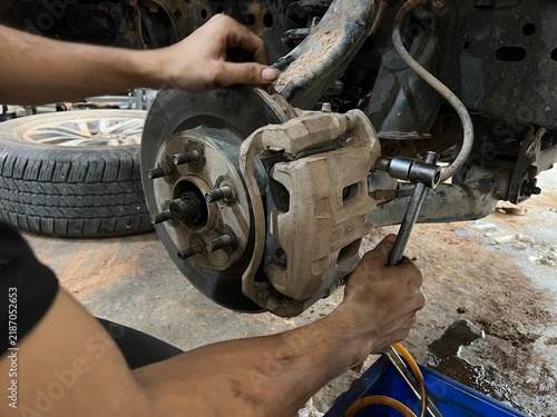 Foto Car suspension and brakes  Mechanical view of suspension coil spring, control arm, and disc brake assembly without wheel