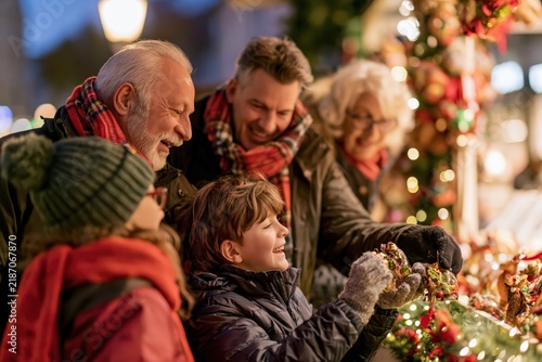 Grandparents and grandchildren selecting handmade Christmas ornaments outdoors