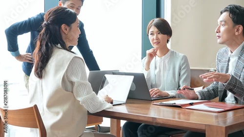 オフィスで会議するカジュアルなビジネスパーソンのグループ