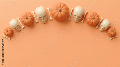 Halloween flat lay with pumpkins and skulls, spooky autumn border on orange background, festive seasonal decor for greeting cards