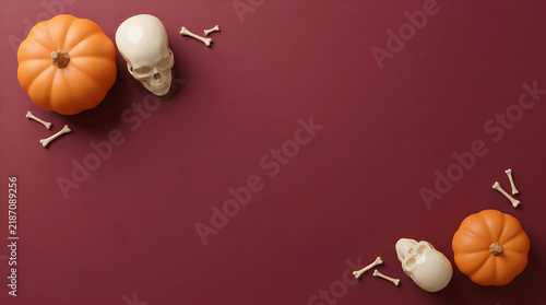 Halloween flat lay with pumpkins and skulls on dark red background. Spooky autumn border with bones. Seasonal holiday frame.