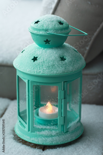 Foto A teal lantern with a glowing candle stands on a frosty step