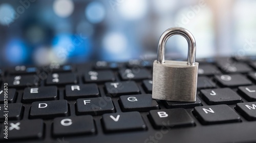 Metal padlock resting on a black computer keyboard representing digital security with keyboard office setting padlock sits top silver metal infrastructure authentication safety