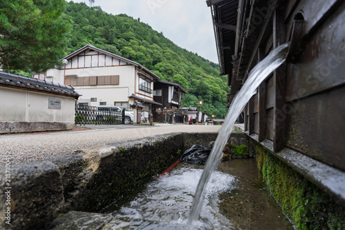 Water flows from natural spring on quiet street in traditional village - Kiso-Fukushima, Japan