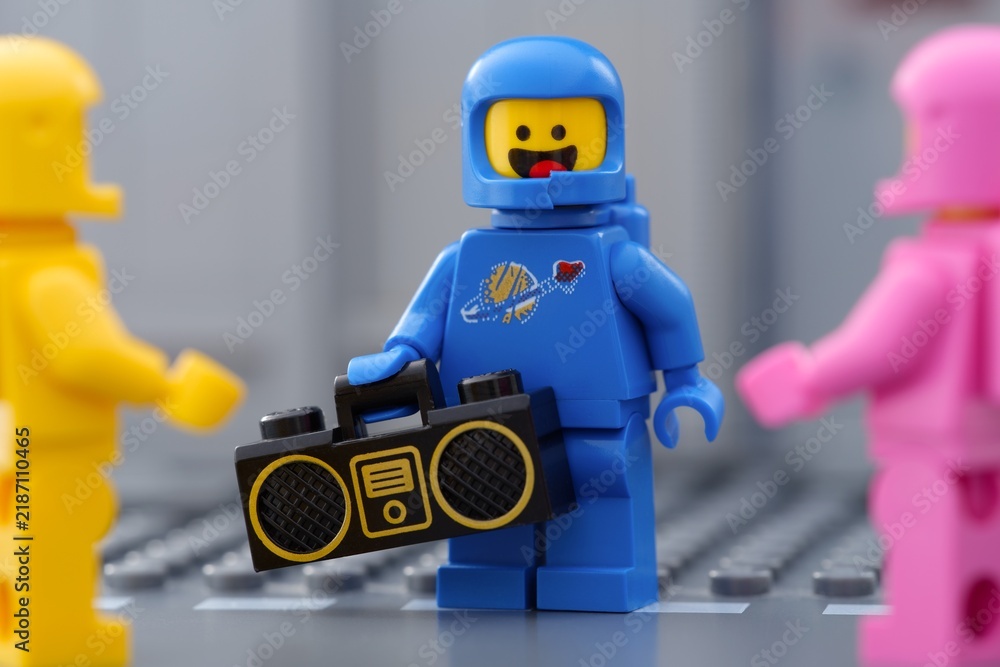 Obraz premium Tambov, Russian Federation - May 30, 2025 Close-up shot of Blue Lego astronaut minifigure holding a boombox standing next to two other Lego cosmonauts