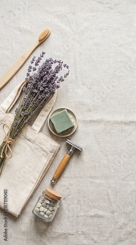 Eco-friendly personal care items and dried lavender on a light fabric background, showcasing sustainable lifestyle products.