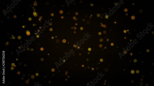 Golden bokeh particles floating on black background motion