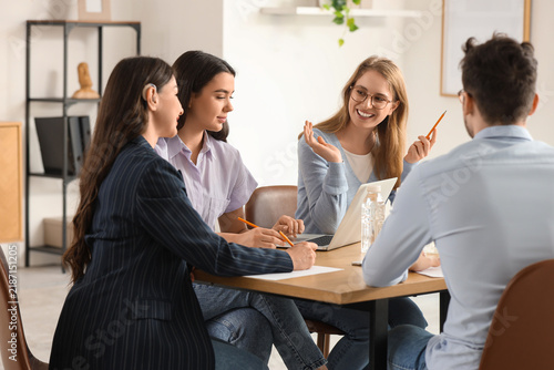 Young woman with hearing aid and human resources commission in office