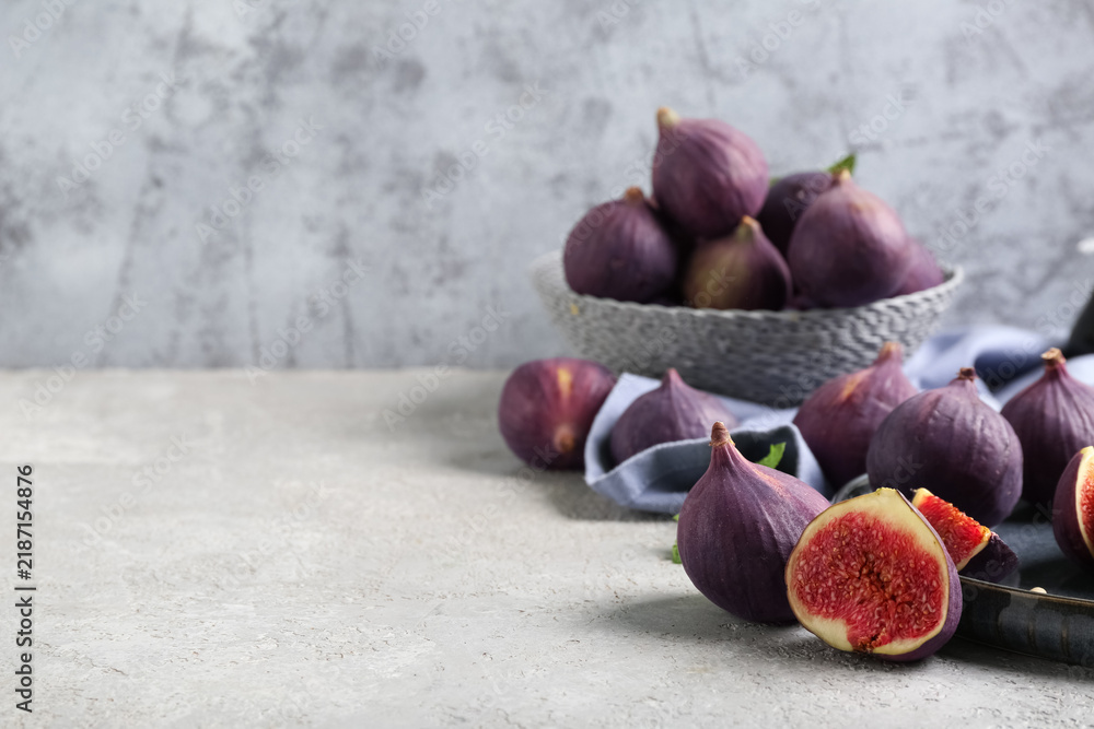 Obraz premium Plate with fresh ripe figs on grey grunge table, closeup