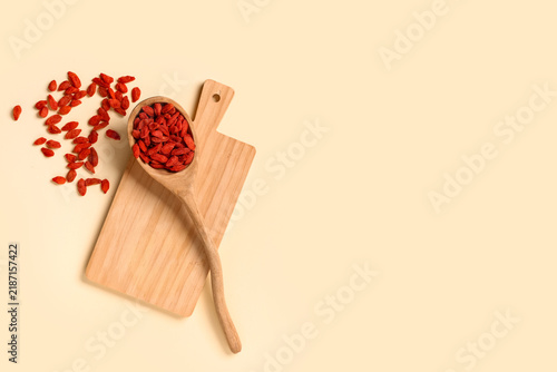 Canvastavla Wooden spoon with red dried goji berries on yellow background