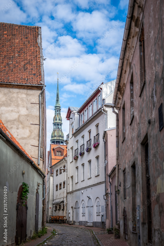 Obraz premium Riga Old Town Alley Framing St. Peter’s Church Spire