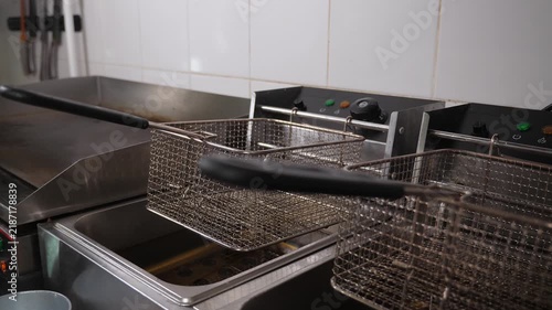 Close-up of empty deep-fryers in the restaurant's industrial kitchen. Two empty fryers for French fries and nuggets in the kitchen of a fast food restaurant.
