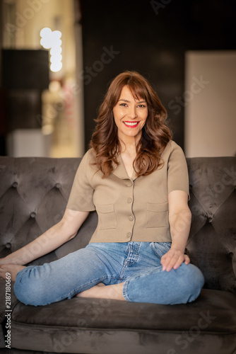 Portrait of smiling mature woman sitting on couch at home