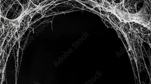 Dusty old white spiderweb hanging in the corner of a dark abandoned room with intricate white strands