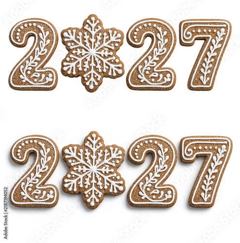 Gingerbread cookie shaped like the number 2027, decorated with white icing patterns; a snowflake-shaped cookie dusted with powdered sugar replaces the zero, isolated against both white and transparent