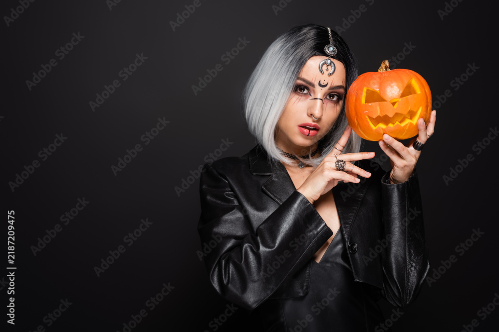 Naklejka premium Gothic witch with crescent moon symbol poses for Halloween portrait