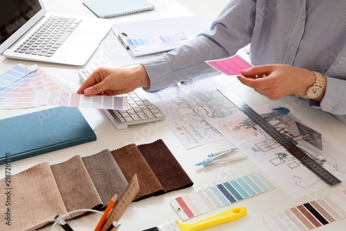 Female interior designer working with color palettes at table in office