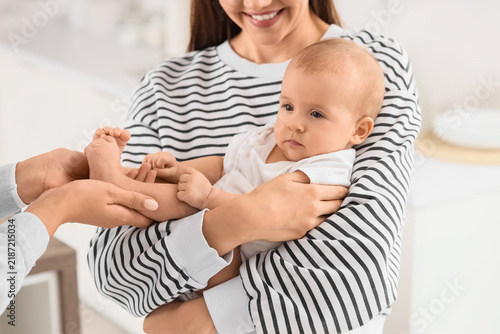 Young lesbian couple with their little baby in kitchen, closeup