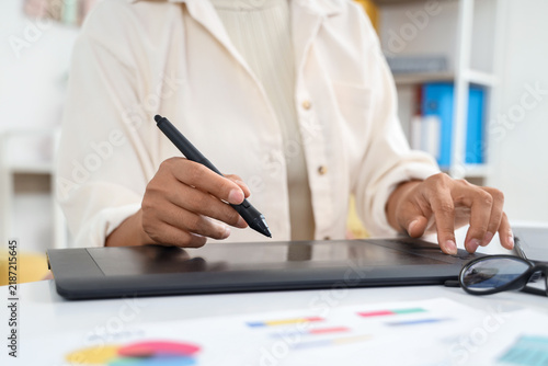 Female web designer working with graphic tablet at table in office  closeup