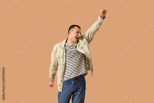 Handsome young happy man on beige background