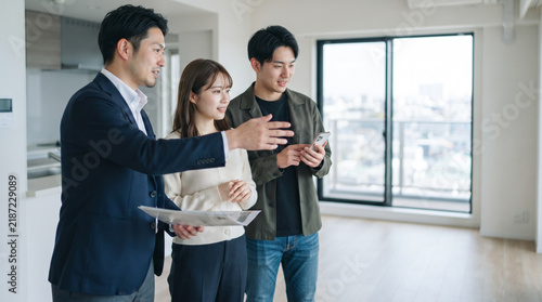 Fototapeta 不動産会社の内見案内でマンションの室内を見学する若い夫婦