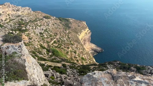 Panoramic view from the spectacular Dingli Cliffs in Malta, overlooking rugged limestone cliffs and the deep blue Mediterranean Sea. Scenic coastal landscape on a sunny summer day
