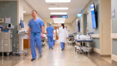 Busy hospital hallway with blurred medical professionals walking abstract background with flowing shapes and lines