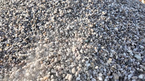 crushed stones trickle onto a pile