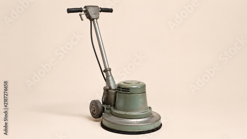 Vintage floor buffer on neutral studio background