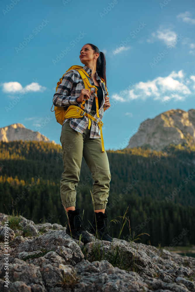 Fototapeta premium Woman hiking in mountains embracing nature and adventure