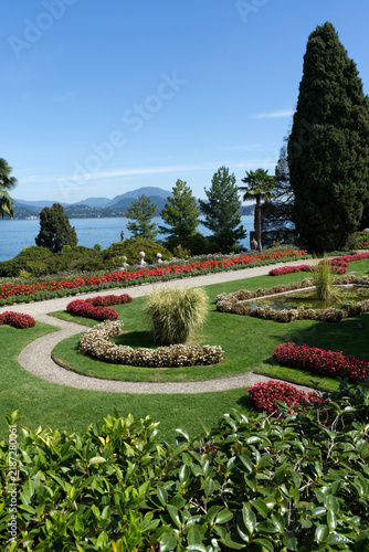 Beautiful manicured Italian garden overlooking a scenic lake and mountains on a sunny day