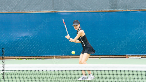 Fotografía Young Asian Woman Playing Tennis, Hitting Forehand Shot Near Net on Outdoor Cour