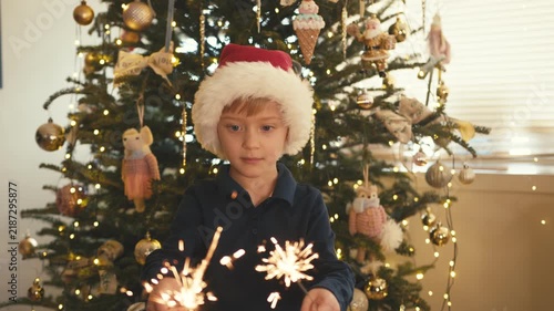 Little boy with santa hat playing with sparklers