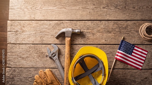 Construction Tools Yellow Hardhat and USA Flag on Wooden Surface