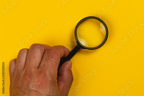 Searching with a magnifying glass on a yellow background