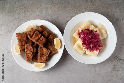 Crispy pork chicharron served with boiled cassava and pickled red onion