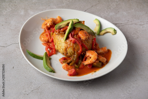 Caribbean mofongo with shrimps in Creole sauce and avocado slices