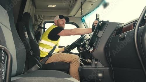 Professional truck driver using smartphone in cabin