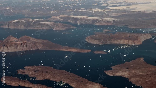 Greenland aerial landscape view, flying along Salliaruseq Island and Uummannaq Island, located in the Uummannaq Fjord, in the Avannaata municipality in northwestern Greenland  with icebergs swimming